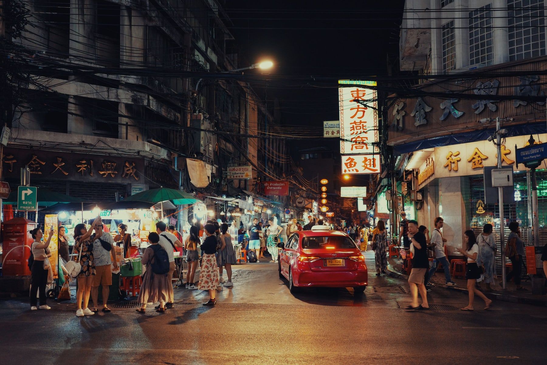 Una calle de Tailandia de noche, con los puestos de comida encendidos