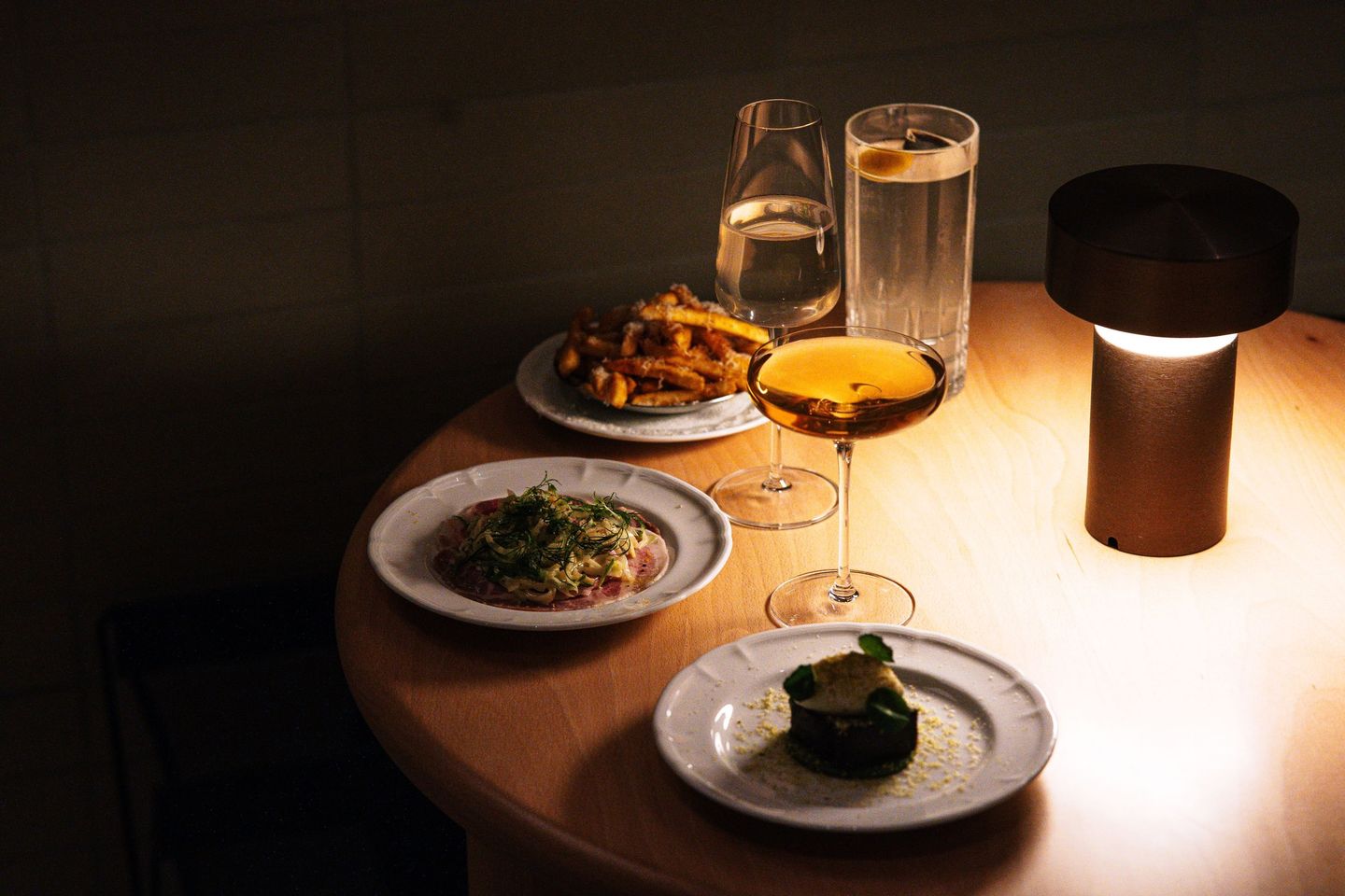 Platos de Krabi para compartir sobre una mesa de madera, de noche